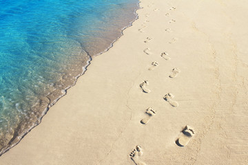 Foot prints on a sandy beach with selective focus