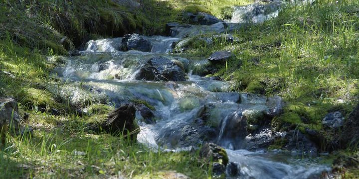 Swift narrow stream tumbling over rocky streambed