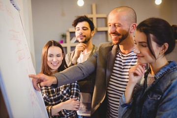 Team of graphic designer discussing chart on white board