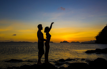 Fototapeta premium Silhouettes loving couple at sunset on the Philippine Islands