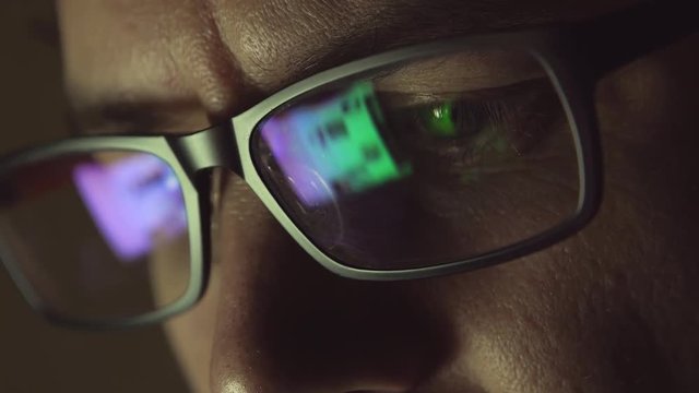 The reflection at the glasses of man: looking a site (side view)