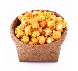 Caramel Popcorn in basket on white background