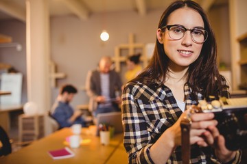 Graphic designer holding pictures in camera