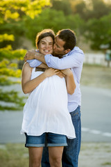 Obraz premium happy couple in love together in park landscape on sunset with woman pregnant belly and man