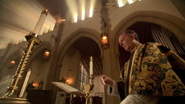 Priest at altar, lifting bread and wine during Eucharist