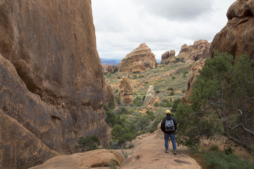 Hiker on the trail to Double O Arch at Arches National Park in Moab Utah.