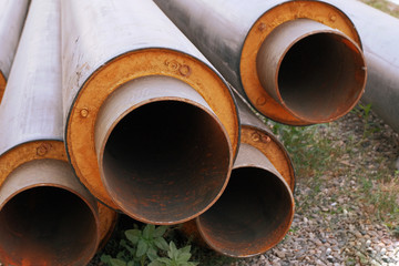 Steel water pipes with PVC isolation shell in stack on ground in construction site