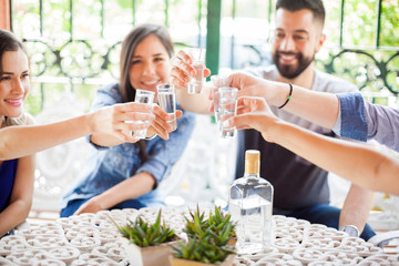 Group of friends making a toast with tequila - Powered by Adobe