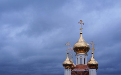 Obraz premium Golden domes of orthodox church and cloudy sky