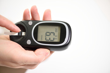 First type Diabetes patient measuring glucose level blood test use glucometer and small drop of...