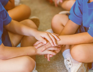 Two children holding hands in the school.