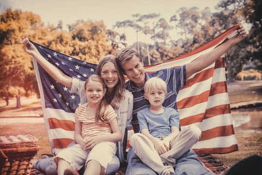 Hapy Family Holding American Flag In The Park