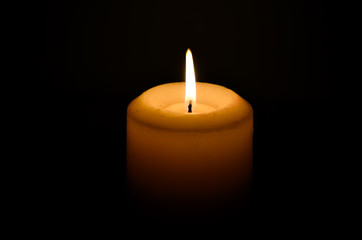 Obraz na płótnie Canvas Burning candle on a dark background