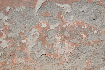 Old pink painted plaster gray peeling wall