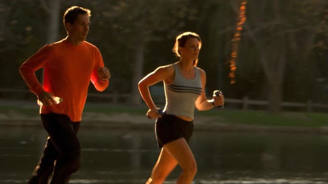 Couple running past a pond