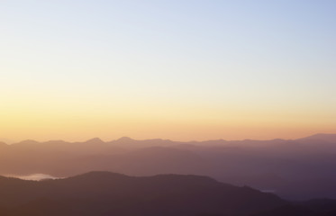 Climbing young adult at the top of summit with aerial view of th