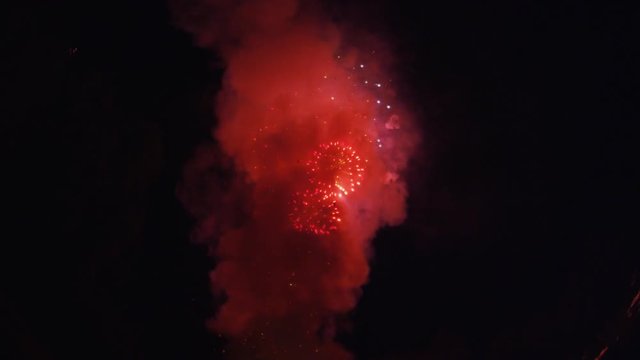 Rockets shoot into frame from below and both sides to burst in multicolor smoky explosions