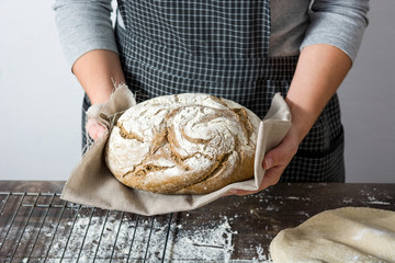 young woman with a rustic bread in hand