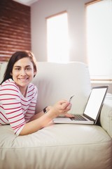 Fototapeta premium Portrait of young woman using laptop