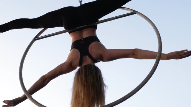 Air gymnastics woman hang and fly at sky