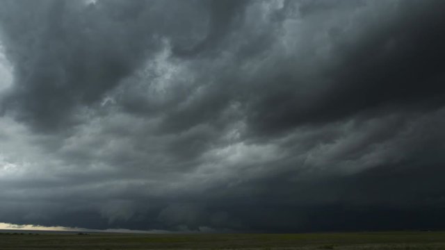 Dark storm clouds blowing just above a prairie landscape, time lapse