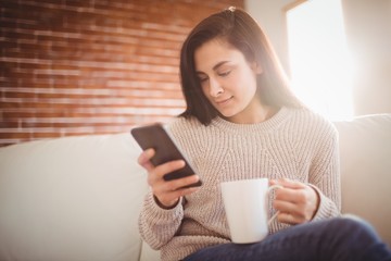 Woman using mobile phone at home