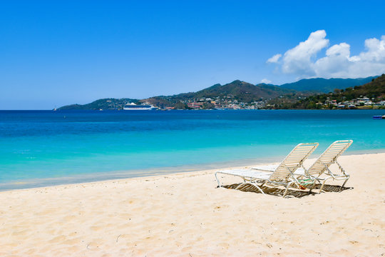 Beach chairs on white sandy beach in Grenada, the Caribbean