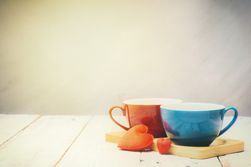 red and blue coffee cup on wooden tray / two red heart on old wh