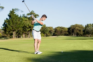 Obraz premium Concentrated golfer man taking shot 