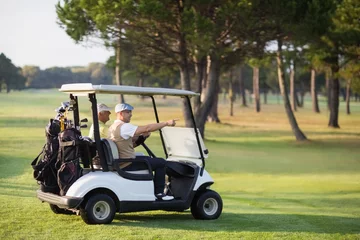 Tableaux ronds sur plexiglas Golf Mature golfer friends sitting in golf buggy