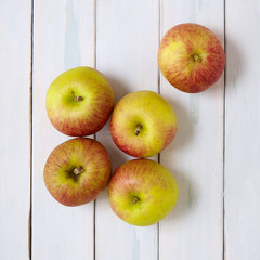 Red apples on a rustic painted wooden background