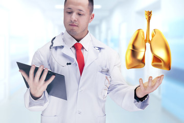 Doctor holding golden human organs and tablet in a hospital . High resolution.