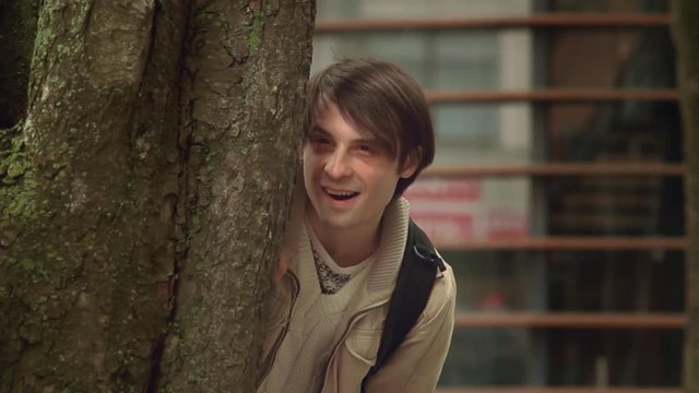 Man Spying Hiding Behind a Tree