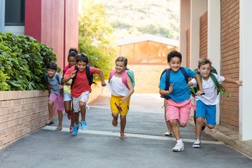 Schoolchildren running on footpath 