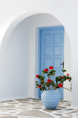 Home exterior with blue door and flowers in Greece