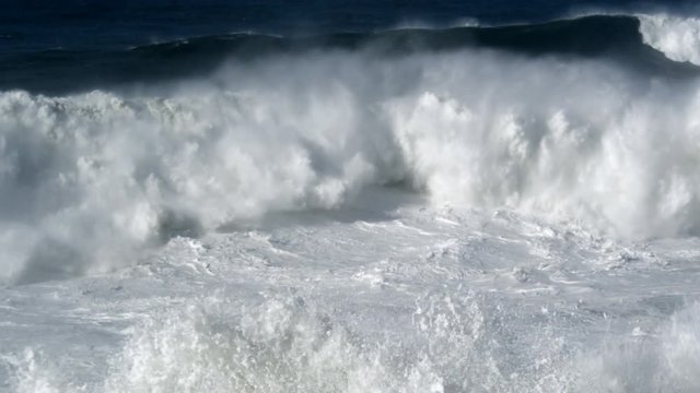 Surging breakers crash onto ebbing foam