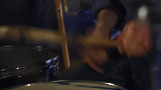 Man drummer energetically plays rock music close-up handle shot