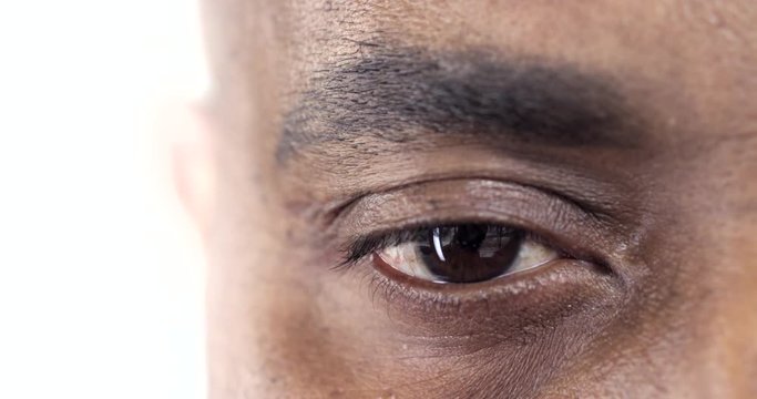 Businessman's Tired Eyes/Slow motion shot of an eye of an Afro-American man. He looks straight to the camera. He is tired