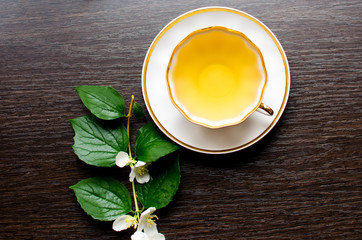 Jasmine tea in a porcelain Cup on a dark wood