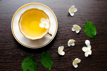 Jasmine tea in a porcelain Cup on a dark wood