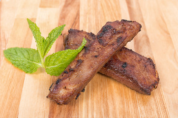 Roasted pork ribs on wooden plate