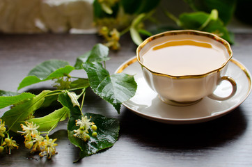 porcelain Cup of Linden tea on a background of dark wood