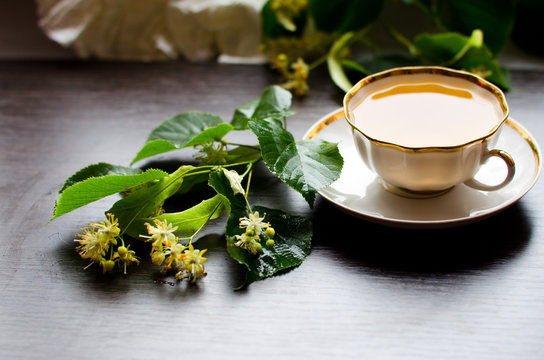 porcelain Cup of Linden tea on a background of dark wood