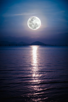 Romantic scenic with full moon on sea to night. Reflection of moon in water. 