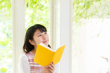 部屋で本を読む女性