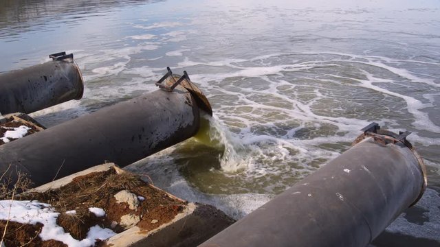 Discharge pipes, one dumping greenish water into Tule Lake