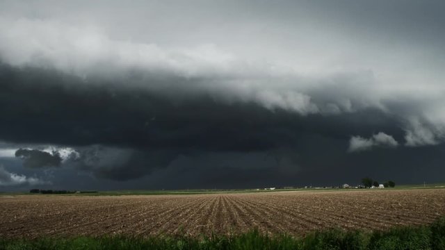 Huge shelf cloud out ahead of a cool outflow of air from a thunderstorm above prairie cropland