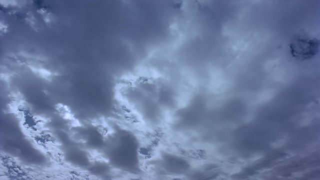 Time-lapse sun behind patchy clouds