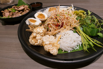 Som Tum or Thai style papaya salad in tray at restaurant