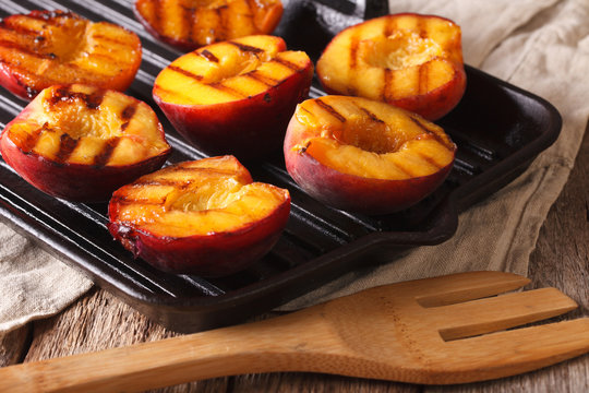 Cooking Ripe peaches on a grill pan close-up. horizontal
